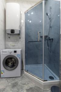 基辅barasport city apartments的带淋浴的浴室和洗衣机。