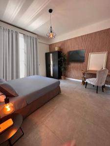 科莫Appartamento Dolce Vita - Parking & Self Check-in的卧室配有1张床、1张桌子和1把椅子