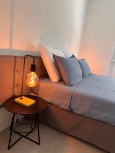 科莫Appartamento Dolce Vita - Parking & Self Check-in的一张带枕头的床和一张桌子上的台灯