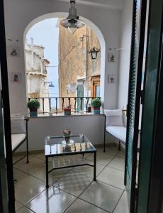 波西塔诺YourHome - La Dimora Di Nonna Angela的客房设有桌子、两把椅子和窗户。