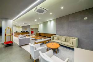 格拉玛多Laghetto Resort Golden Oficial的带沙发和桌椅的等候室