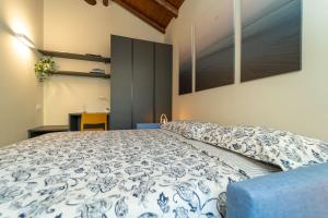 科莫Moderno Appartamento a 200 metri dal Duomo的一间卧室配有一张带蓝色和白色棉被的床