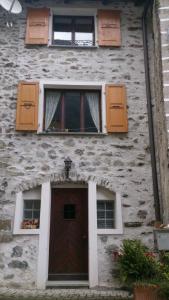 布鲁西奥Al Piazzo 414的一座石头建筑,设有门和两扇窗户