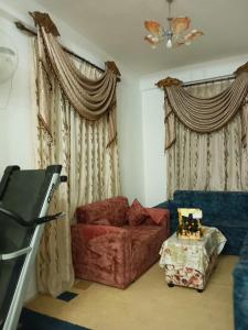 安曼Flowers apartment的客厅配有红色的沙发和窗帘
