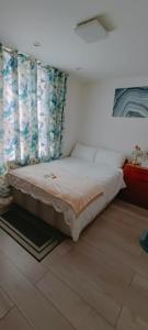 斯坦维尔Min Su Rooms的一间卧室配有一张带窗帘的大床