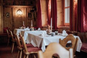 莱赫阿尔贝格戈尔登博格酒店的一间设有白色桌椅和窗户的用餐室