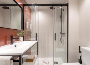 巴塞罗那Arrivo Apartments的一间带玻璃淋浴和水槽的浴室