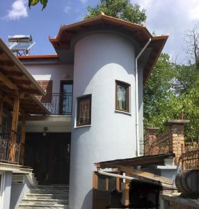 戈里察Vila Tradicionale Violeta Korce的带阳台和楼梯的白色房屋