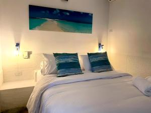 罗克斯群Posada Lagunita的卧室配有白色的床和2个枕头