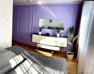 莱比锡Leon Art Apartment的一间卧室配有紫色墙壁和镜子