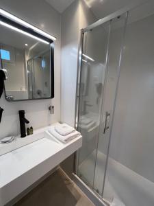 克劳德圣克劳德酒店的一间带玻璃淋浴和水槽的浴室