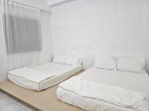 卢穆特Fukuda Minshuku Japanese style的白色墙壁客房的两张床