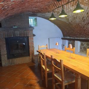 Andorno MiccaCascinaMirta的一间带长桌和壁炉的用餐室