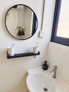三亚闲肆民宿的一间带镜子和水槽的浴室