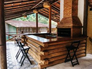 弗洛里亚努元帅镇Sítio Rustico de Lazer 3Km do Centro的一间酒吧,位于一座带两个凳子的房子的庭院