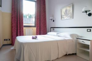 波雷塔泰尔梅Hotel Italia的卧室配有白色的床和窗户。