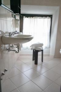 波雷塔泰尔梅Hotel Italia的白色的浴室设有水槽和凳子
