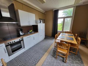 KauhajokiKokon Hovi的厨房配有白色橱柜和桌椅