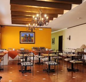 圣萨尔瓦多维拉特拉酒店的一间设有桌椅的用餐室和黄色的墙壁