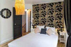 皮埃尔菲特－内斯塔拉AU COEUR DES MONTAGNES的卧室配有一张白色大床和壁画