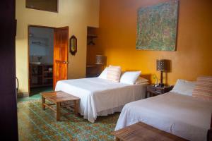 格拉纳达Hotel La Polvora的酒店客房设有两张床和一张桌子。