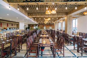萨帕Grand Flamant Hotel Sapa的一间设有木桌和椅子的长餐厅