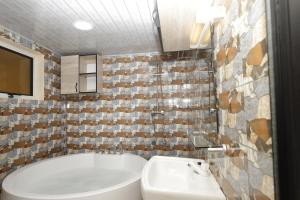 洛美Villa Flo Residence的带浴缸和盥洗盆的浴室