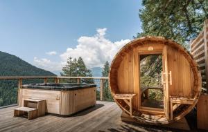 莱索尔Studio Cocon aux Orres 1650 au pied des pistes et vue montagne的在树屋甲板上的热水浴池中泡澡