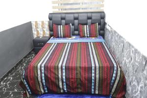 洛美Villa Flo Residence的床上有色彩缤纷的毯子和枕头