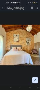 普韦布拉桑纳比亚APARTAMENTOS TURISTICOS LAS CANDELAS的一间卧室设有一张床和石墙