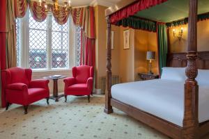 克鲁Crewe Hall Hotel & Spa - Cheshire的一间卧室配有一张床和两张红色椅子