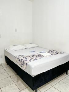 贝伦HOTEL AVENIDA的一张位于白色客房内的床铺,配有床垫