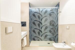 卡利亚里Magnini Rooms的带淋浴的浴室和蓝色壁纸