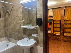 阿布扎比The Villa Hostel Abu Dhabi的浴室配有盥洗盆、镜子和浴缸