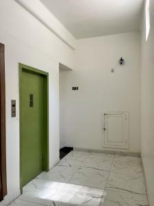 贝伦HOTEL AVENIDA的白色客房的绿色门,铺有瓷砖地板
