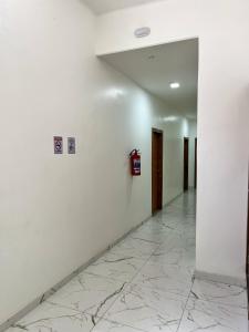 贝伦HOTEL AVENIDA的墙壁上带有白色墙壁和消防栓的走廊