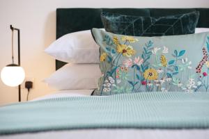 沃尔索尔The Woden Boutique Hotel Walsall M6 J9的一张带蓝色棉被和枕头的床