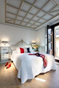 格拉纳达卡萨帕拉萨特1822酒店的卧室配有带红色枕头的大型白色床