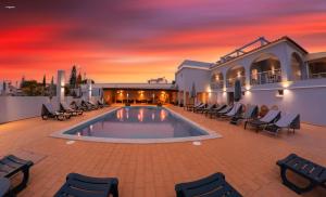 卡武埃鲁Villa Welwitshia的一个带椅子的游泳池,享有日落美景