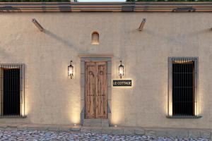 圣米格尔-德阿连德Le Cottage San Miguel de Allende, Modern Luxury in Centro with Pool & Jacuzzi的一座带木门和标志的建筑