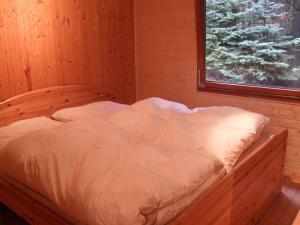 SellerichNice house with sauna and steam bath in a forest的木制客房的一张床位,设有窗户