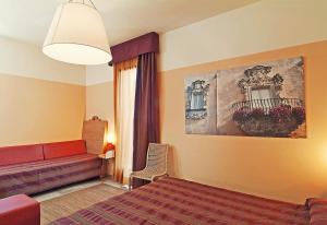 加利亚诺德尔卡波Il Tabacchificio Hotel的一间卧室配有一张床、一张沙发和一个窗口