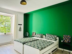 哈根FeWo Ischeland near Hagen-City的绿色卧室,配有床和绿色的墙壁