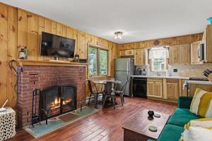 乔治湖Takundewide Retreat的一间带砖砌壁炉的客厅和一间厨房