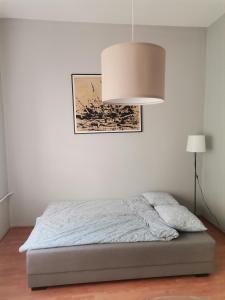 诺维萨德EVA Apartment的白色卧室配有带灯的床