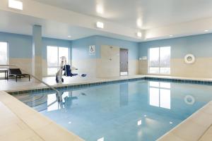 托莱多北托莱多智选假日酒店的蓝色墙壁的建筑内的游泳池