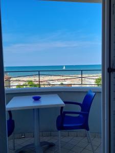 里乔内Residence Saturnia的一张桌子和椅子,享有海滩美景
