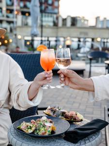 维多利亚Oak Bay Beach Hotel的两人拿着酒杯和桌上的食物