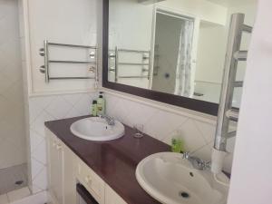 约翰内斯堡Eden Guesthouse的浴室设有2个水槽和镜子