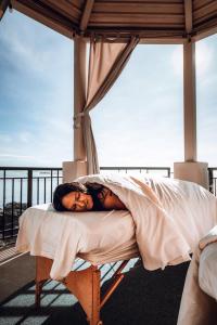 维多利亚Oak Bay Beach Hotel的躺在阳台上的床上的女人